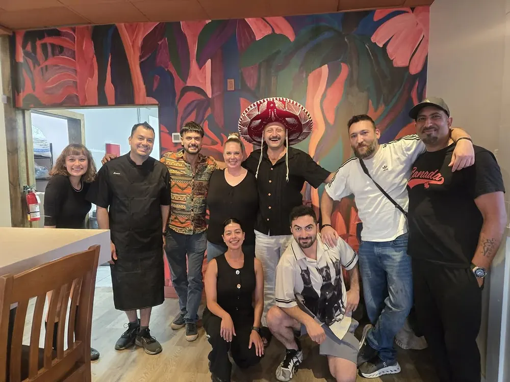 The Lupita team gathered in front of the cantina's painted mural